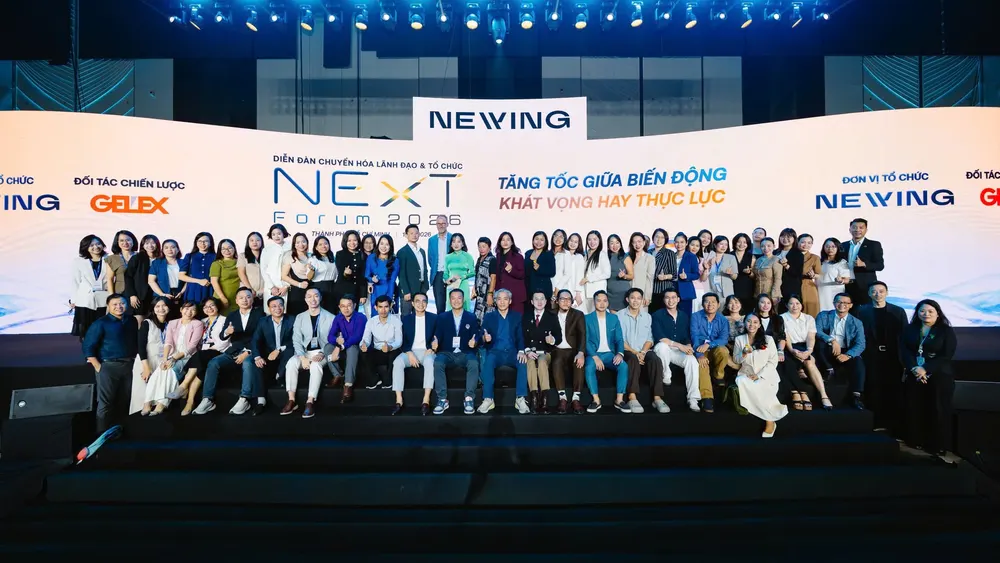 Các đại biểu chụp ảnh lưu niệm trước phông sân khấu Diễn đàn NExT Forum 2026 tại THISKYHALL Sala, TP.HCM